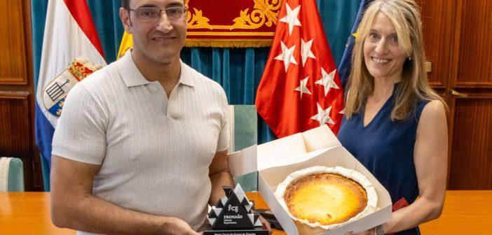 La alcaldesa de San Lorenzo de El Escorial, Carlota López Esteban, ha recibido a Nacho Pontón, de Pastelería Pontón, para felicitarle por el primer premio conseguido en el certamen nacional celebrado en Zamora. Nacho Pontón, de Pastelería Pontón, ha visitado el M.I. Ayuntamiento de San Lorenzo de El Escorial tras proclamarse ganador del I Concurso Nacional a la Mejor Tarta de Queso de España, celebrado en el marco de FROMAGO Cheese Experience 2026. Durante el encuentro, la alcaldesa, Carlota López Esteban, ha trasladado personalmente su felicitación al pastelero por este reconocimiento. Pontón, que cuenta actualmente con dos establecimientos en San Lorenzo de El Escorial, ha compartido cómo fue su participación en el concurso y algunos detalles del proceso de elaboración de la tarta presentada al certamen. En la conversación ha explicado cuestiones relacionadas con los ingredientes empleados, la preparación y los tiempos de reposo, especialmente los utilizados para la elaboración con la que concurrió al concurso. Los asistentes también han podido degustar la tarta ganadora. La receta con la que Nacho Pontón obtuvo el primer premio combina distintos tipos de queso y fue valorada por un jurado especializado junto a las propuestas presentadas por otros profesionales procedentes de diferentes puntos de España. El reconocimiento supone un nuevo logro para Pastelería Pontón y para un establecimiento estrechamente vinculado a San Lorenzo de El Escorial. Pastelería Pontón suma un reconocimiento nacional con la mejor tarta de queso de España
